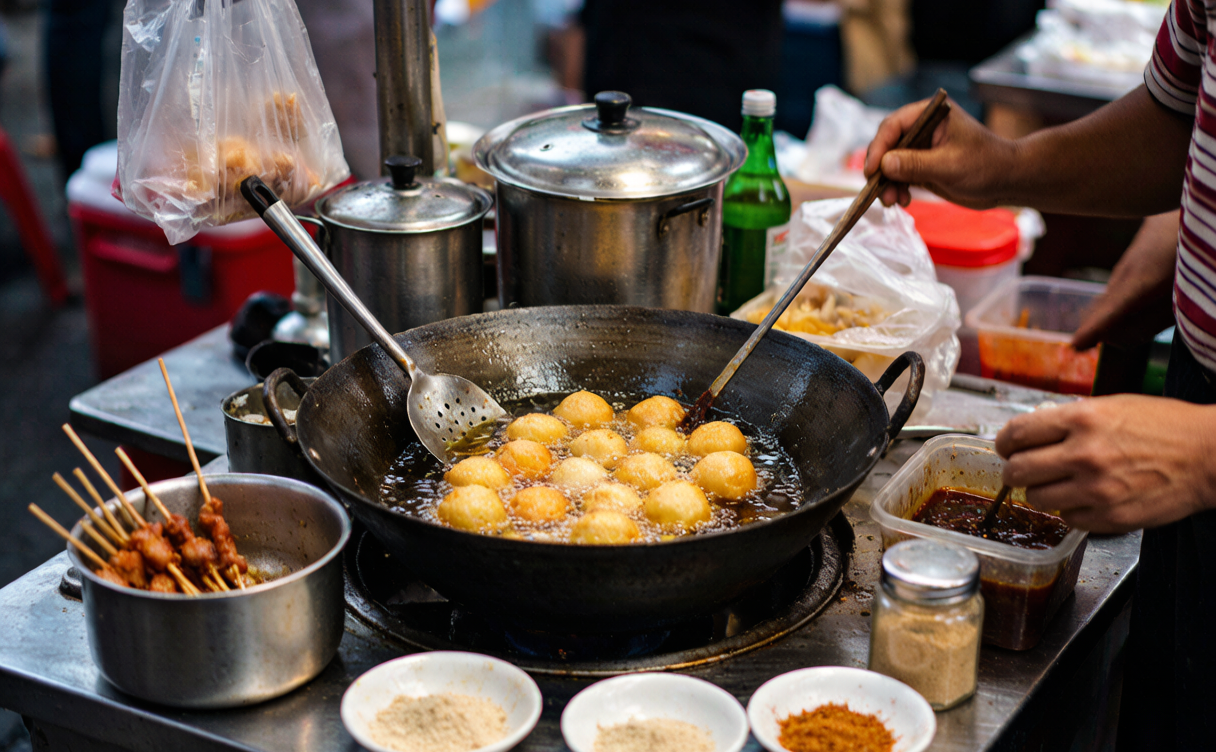 Street vendor frying black stinky tofu at a night market in Changsha, Hunan, China