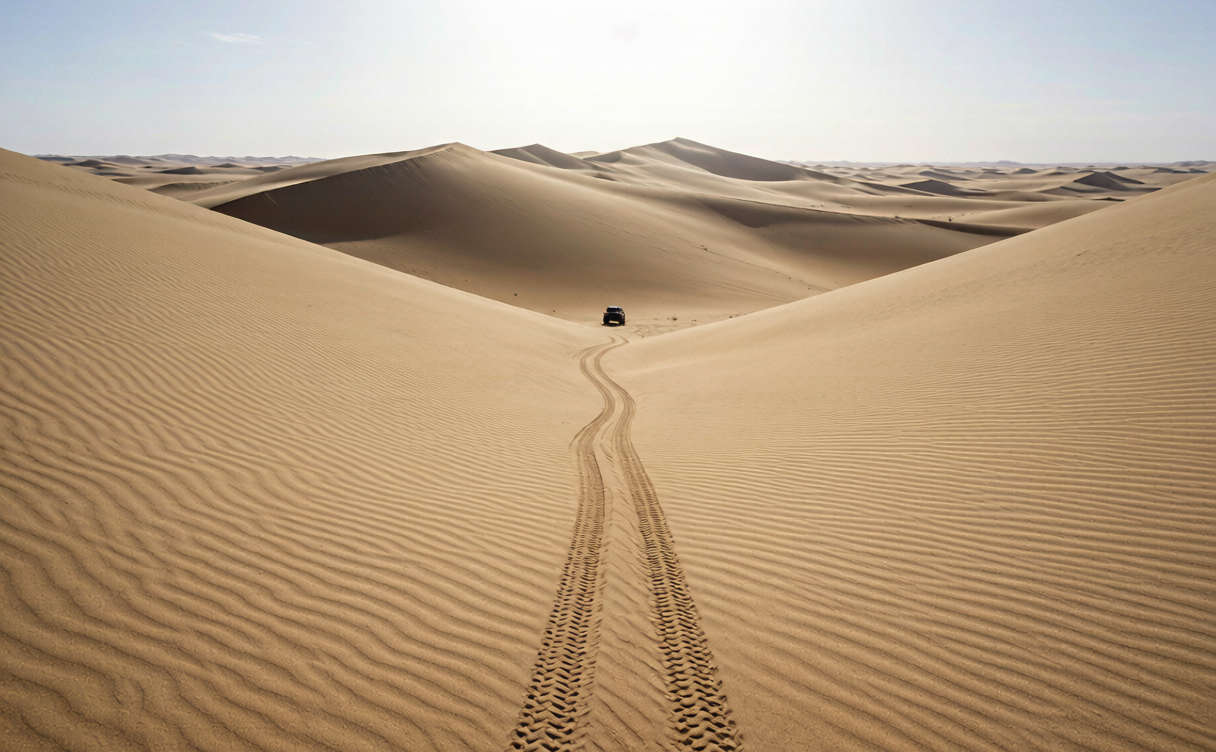 Off-road vehicle leaving tyre tracks on the dunes of Badain Jaran Desert