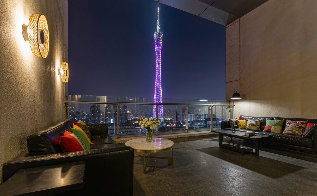 Hotel club lounge terrace with the Canton Tower lit up at night across the Pearl River