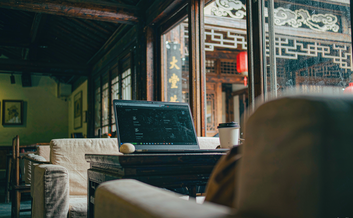 Remote worker with laptop at a sunny table in a Chinese coffee shop