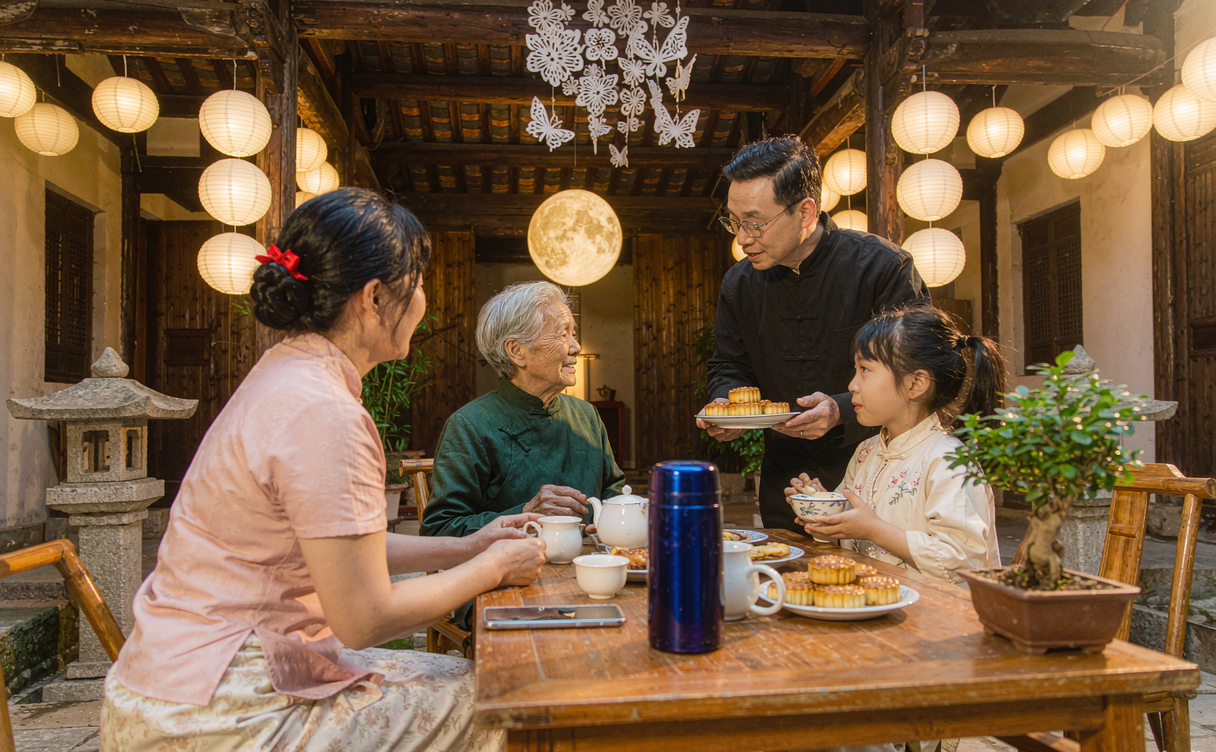 Families celebrating Mid-Autumn Festival under lanterns and a full moon in China