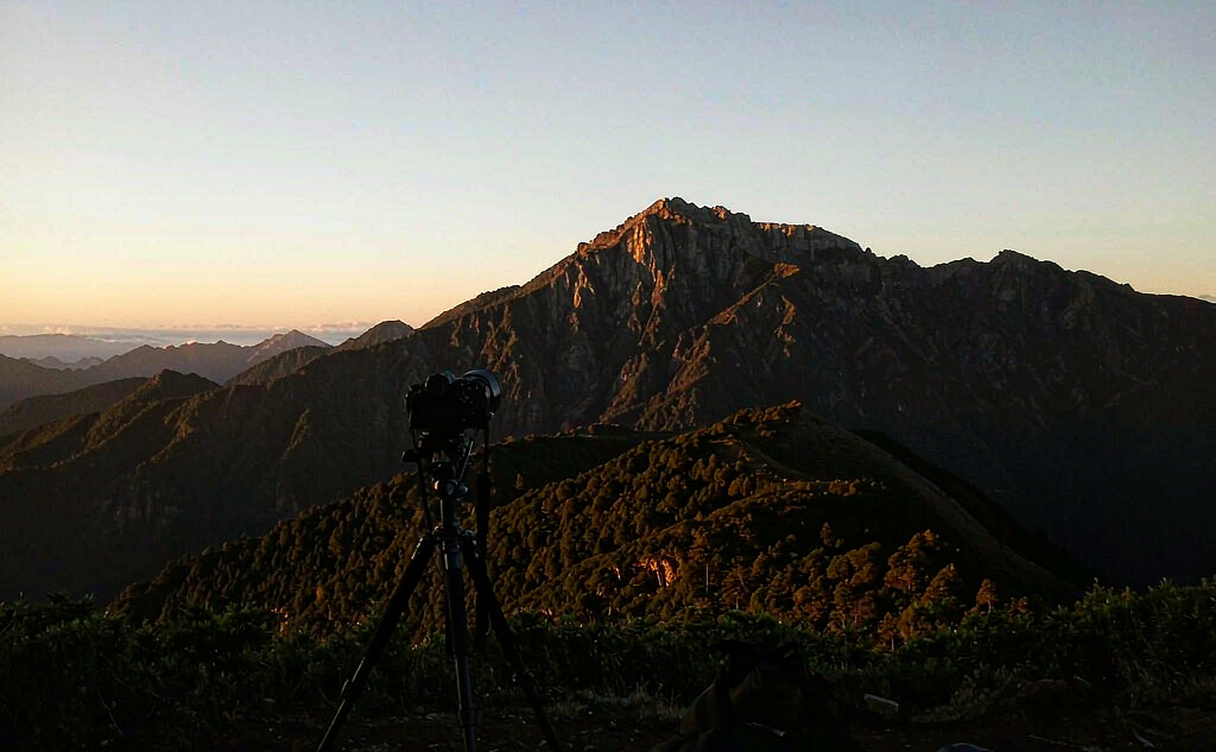 Photographer using a telephoto lens to capture a mountain sunrise in China