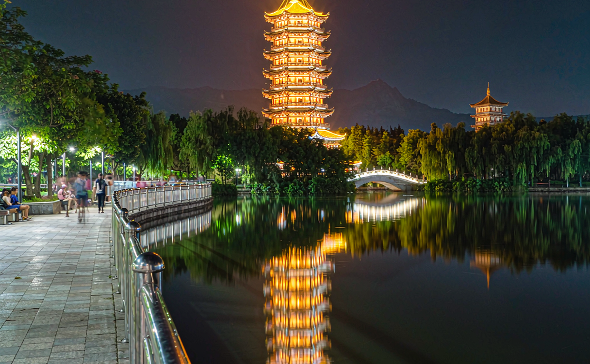 Copper Sun Pagoda of Guilin mirrored in still lake water during blue hour