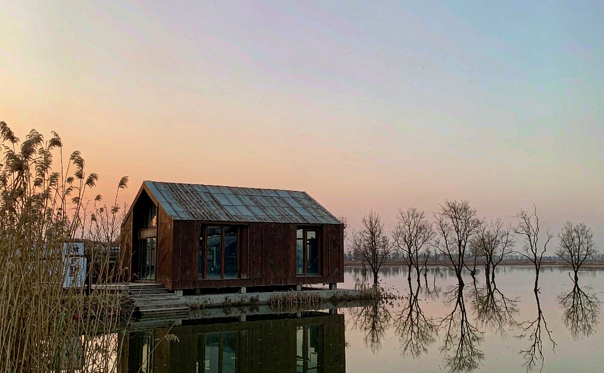 Birdwatching hide among reeds at Hengshui Lake with reflective water at dawn