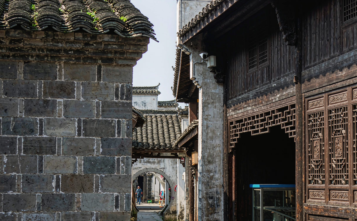 Xidi ancient village stone archway and white horse-head walls at golden hour in Anhui