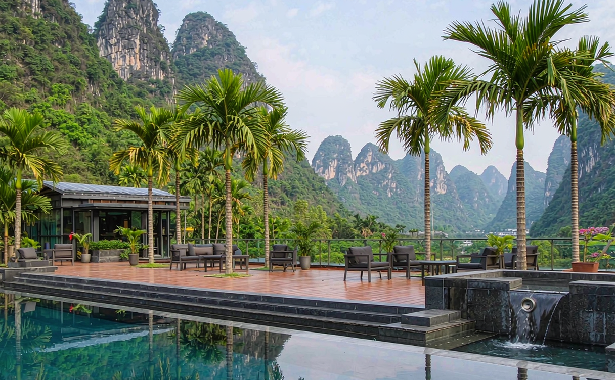 A Yangshuo riverside hotel balcony overlooking the Li River with a rounded karst peak and morning mist