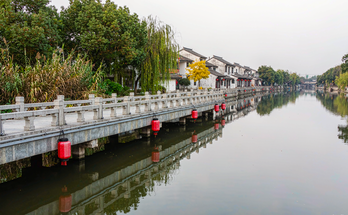 Traditional black-awning boat passing a stone bridge in Anchang water town, Zhejiang, China