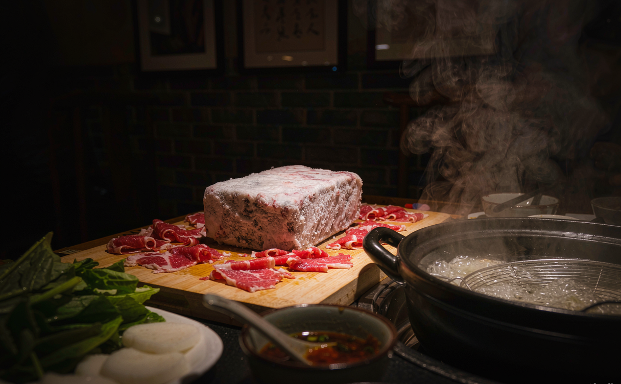 Assortment of Beijing hot pot dipping sauces, tofu, and vegetables on a table in Beijing, China