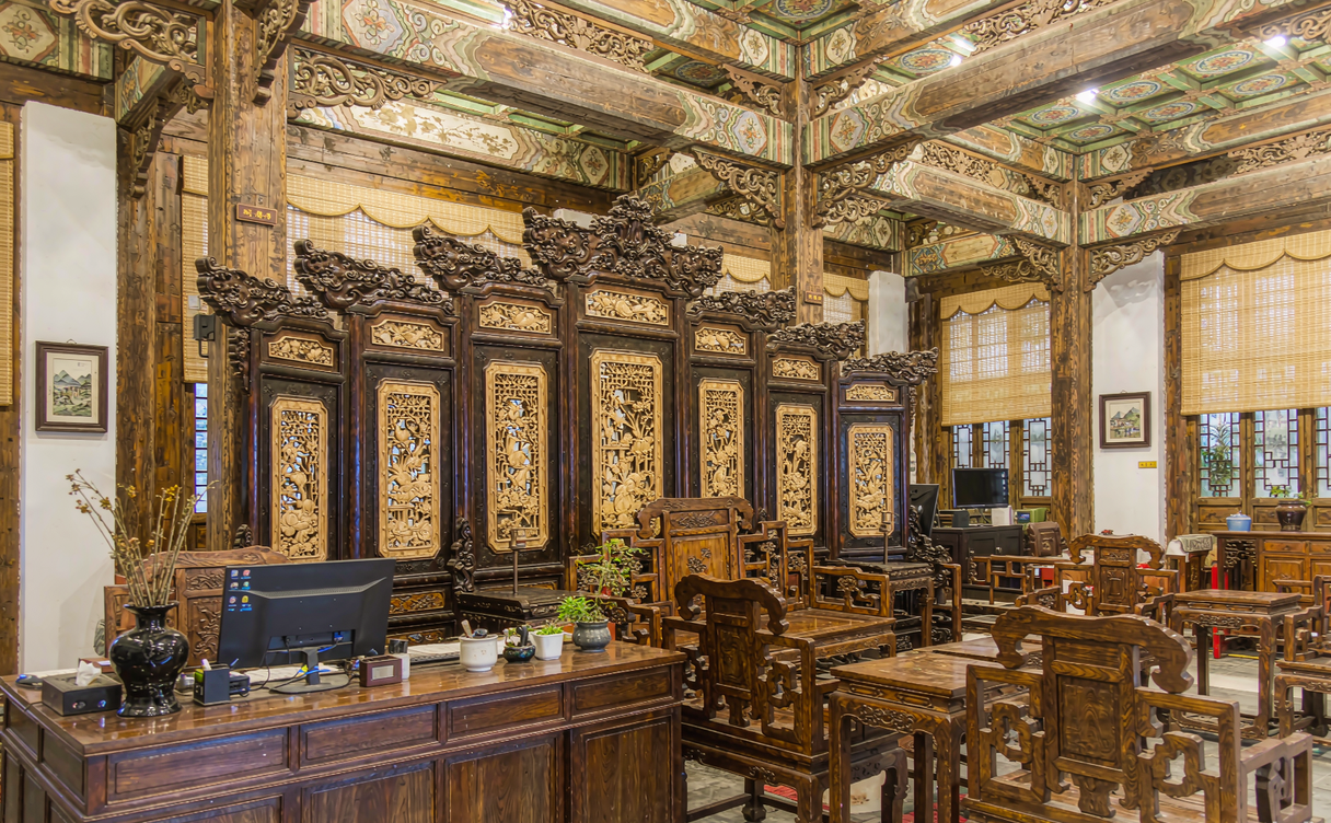 Carved wooden hotel lobby with Qing-dynasty style screens and lattice windows in Chengde