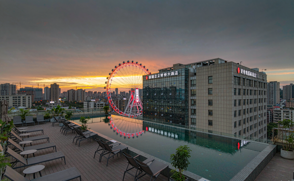 Rooftop pool of a Guiyang business hotel glowing at dusk with the city skyline behind