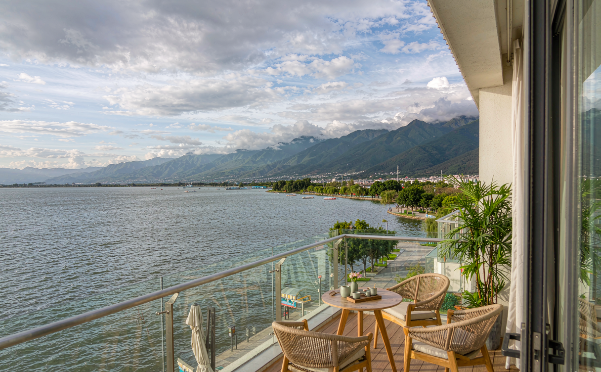 Hotel balcony with view over Qionghai Lake and wooden jetty