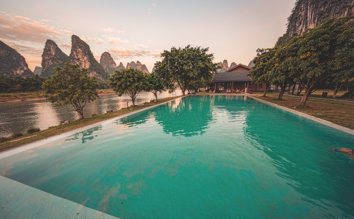 A riverside resort balcony with a direct view of limestone karst peaks over the Yulong River in Yangshuo