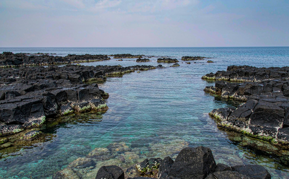 Qizi Bay's flat black rocks and clear shallow water along the Changjiang coast