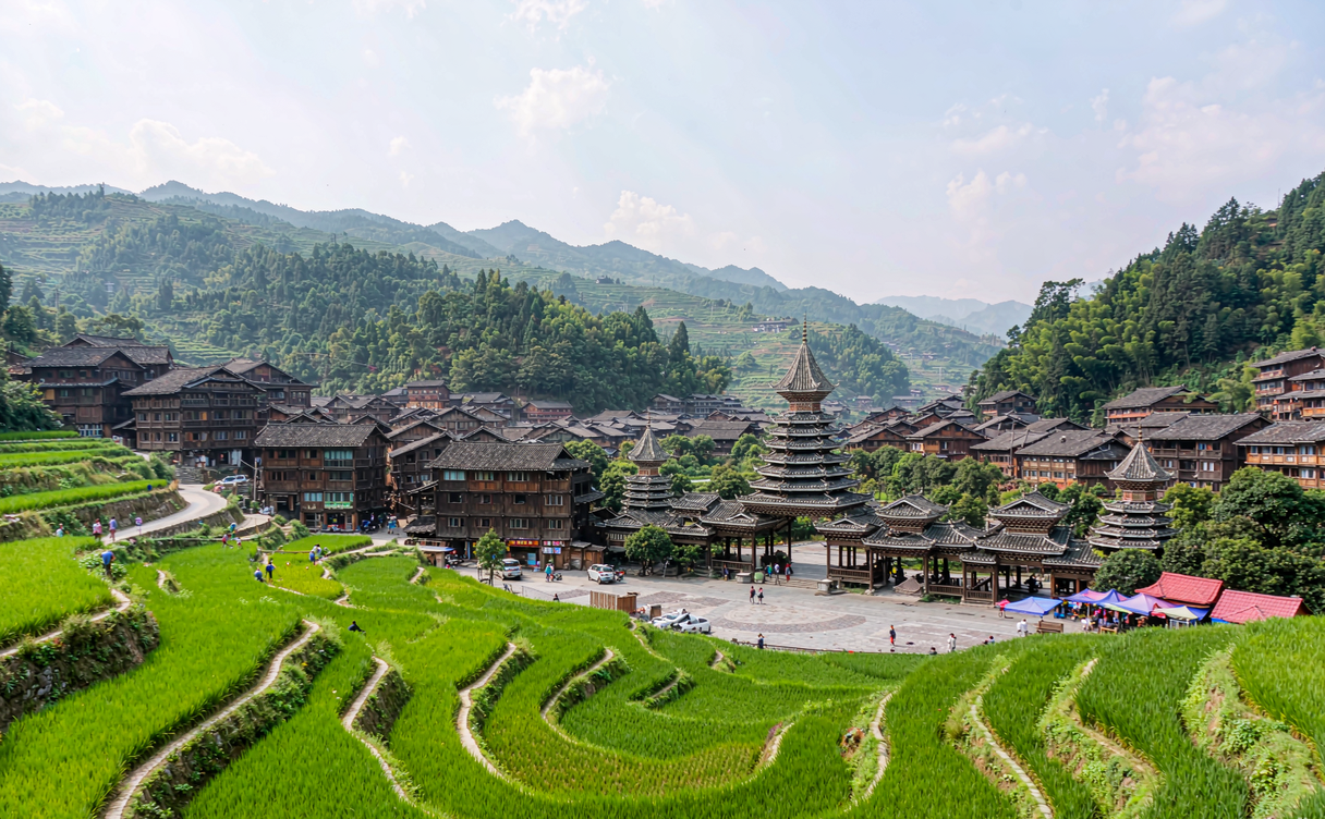 Villagers in indigo Dong dress crossing the covered walkway of Chengyang bridge in Sanjiang, Guangxi, China