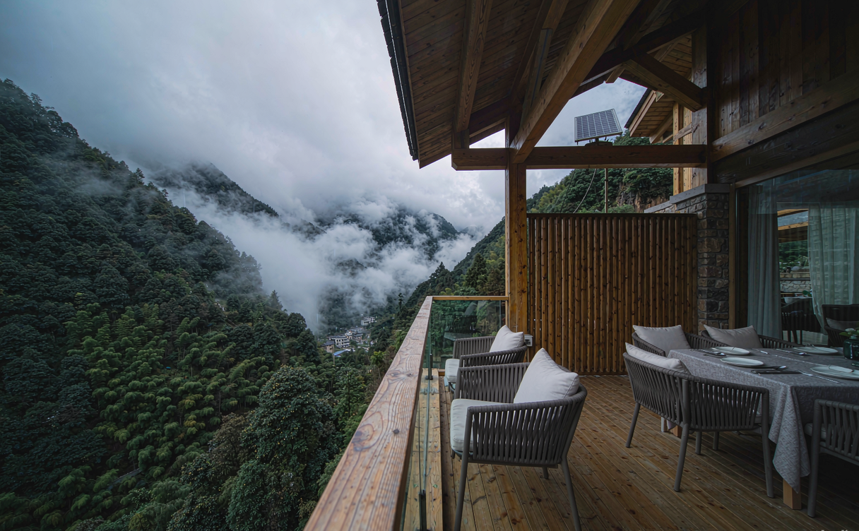 Eco-lodge balcony over a misty terraced valley in Yunnan
