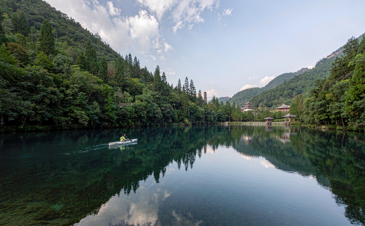 Kayaker on the Yulong River with limestone karst peaks in Guangxi, China