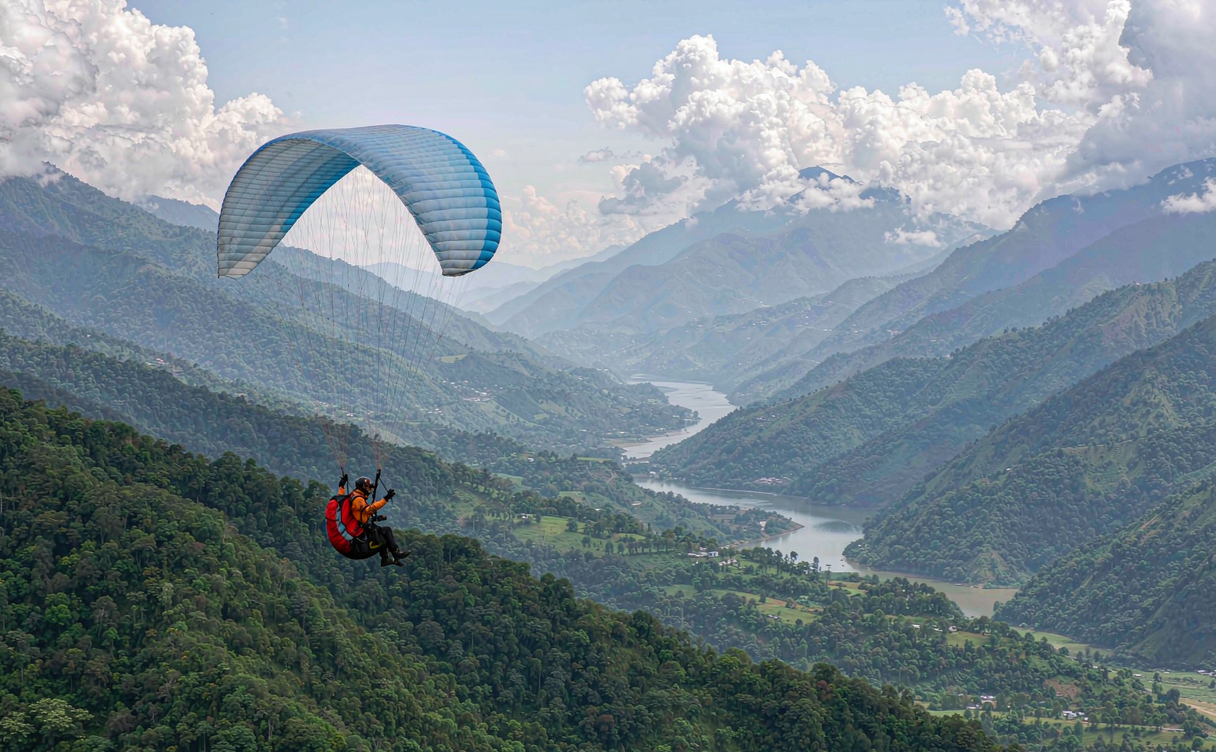 Paraglider launching from a ridge over a river valley in China