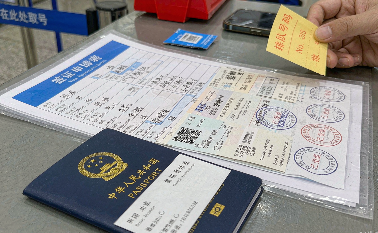 Passport and China visa application documents on a desk
