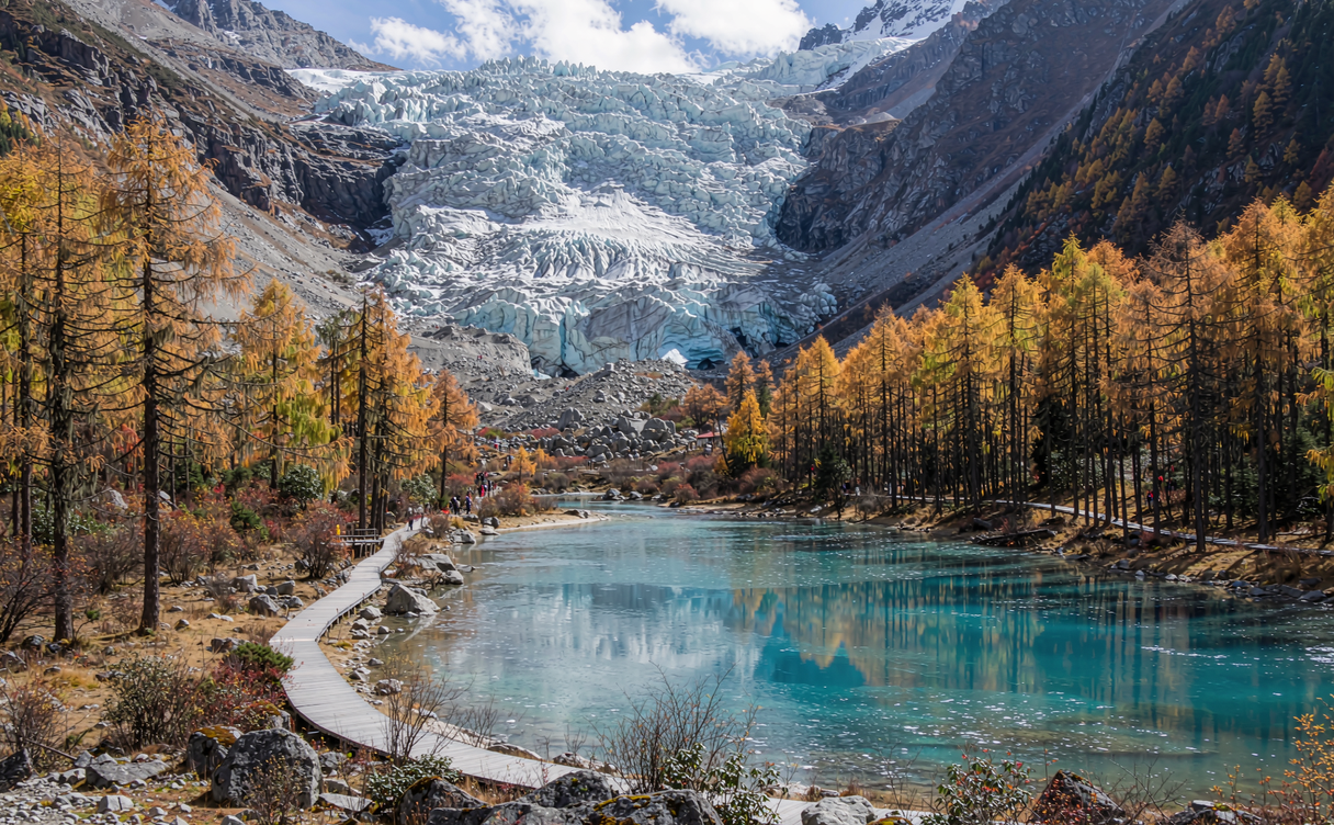 Turquoise glacial lake and yellow larch forest beneath the blue Dagu Glacier ice in Sichuan, China