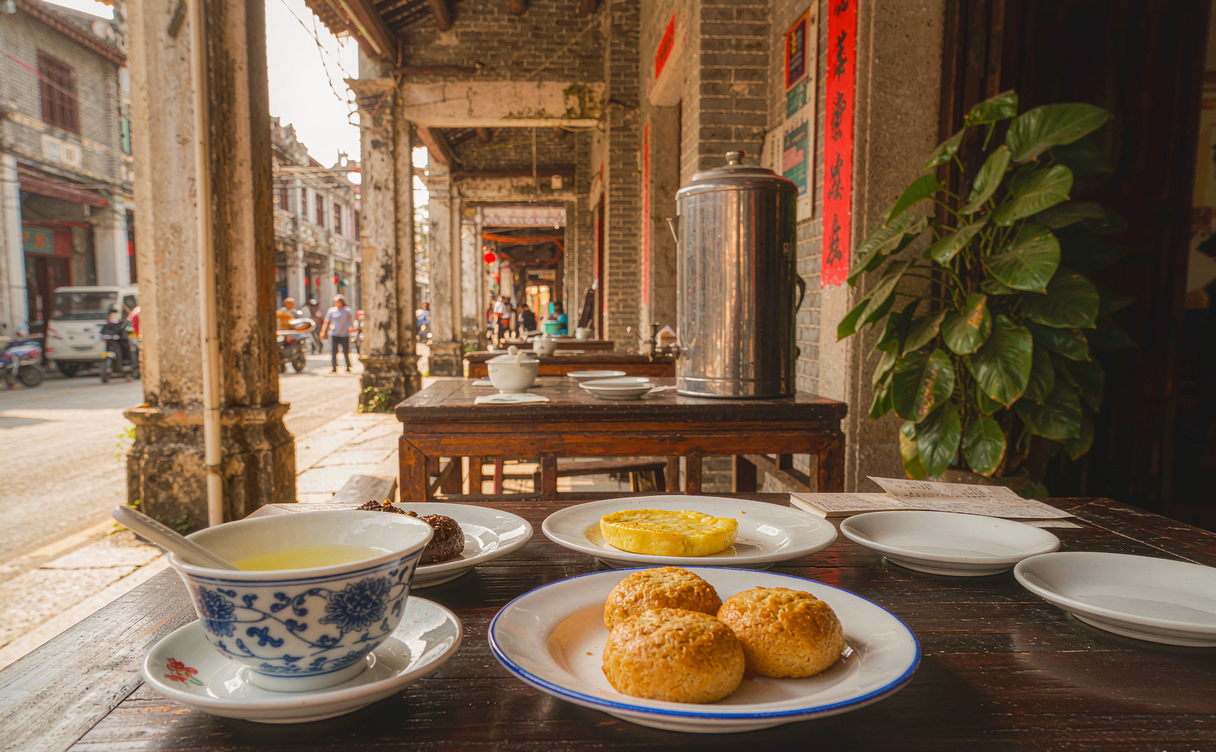 Morning tea plates and brass kettles at an old arcade-street teahouse in Haikou, Hainan