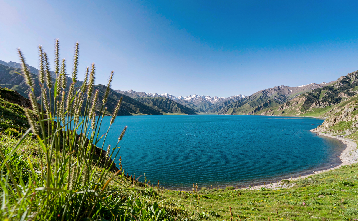 Turquoise Sayram Lake surrounded by mountains and meadows near Huocheng