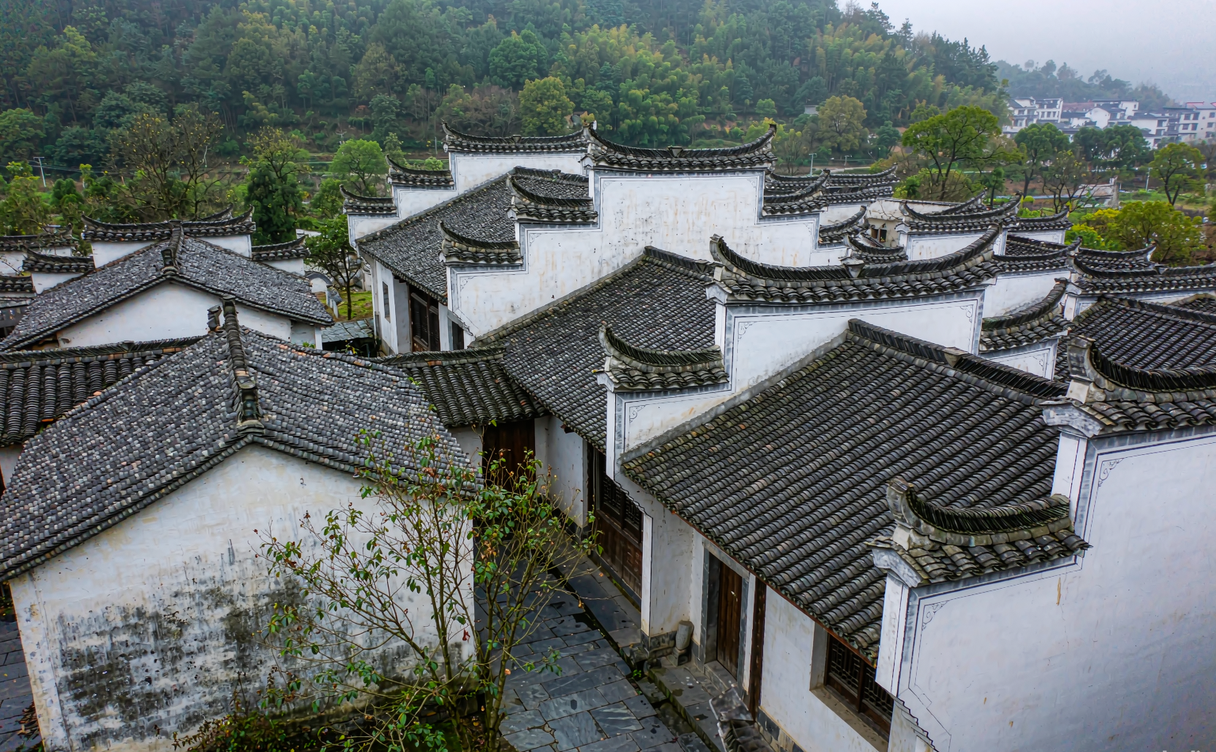 Traditional white-walled Huizhou houses and a stone archway in a Jingde village