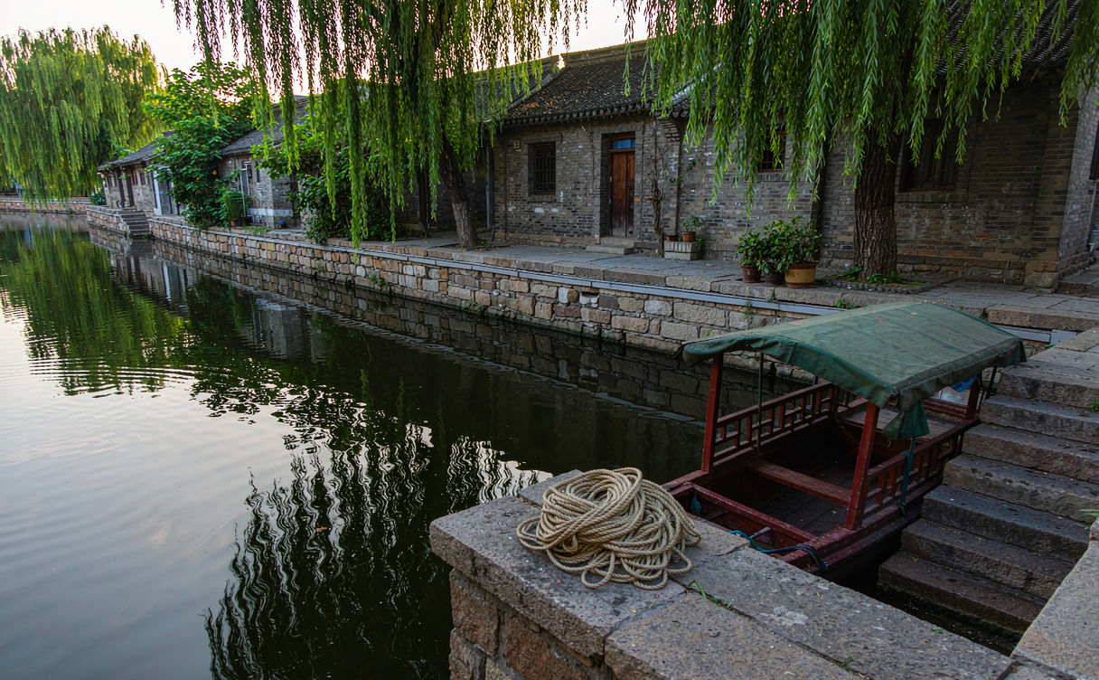 Local resident on a stone quay beside the canal in Jinxi water town, Jiangsu, China