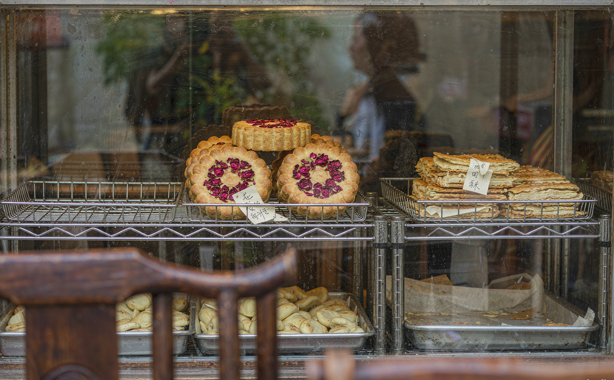 Trays of rose petal flower cakes cooling in a Kunming bakery window display