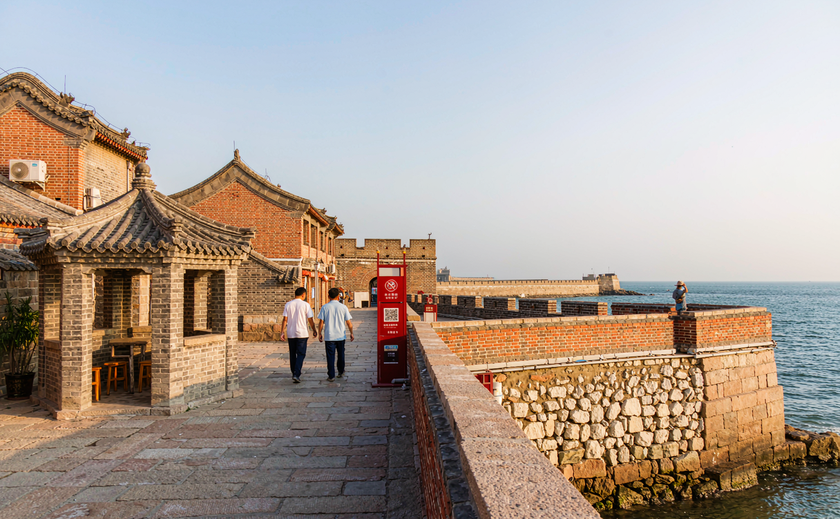 Tourists walking the restored Ming battlements of Laolongtou toward the Sea-Viewing Tower at the seaward end