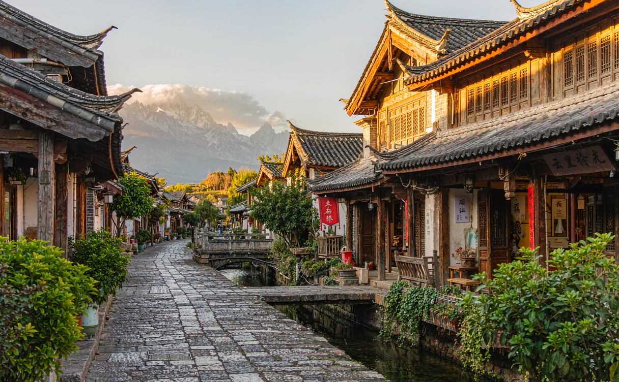 Lijiang Old Town lantern-lit lanes with Jade Dragon Snow Mountain in the distance