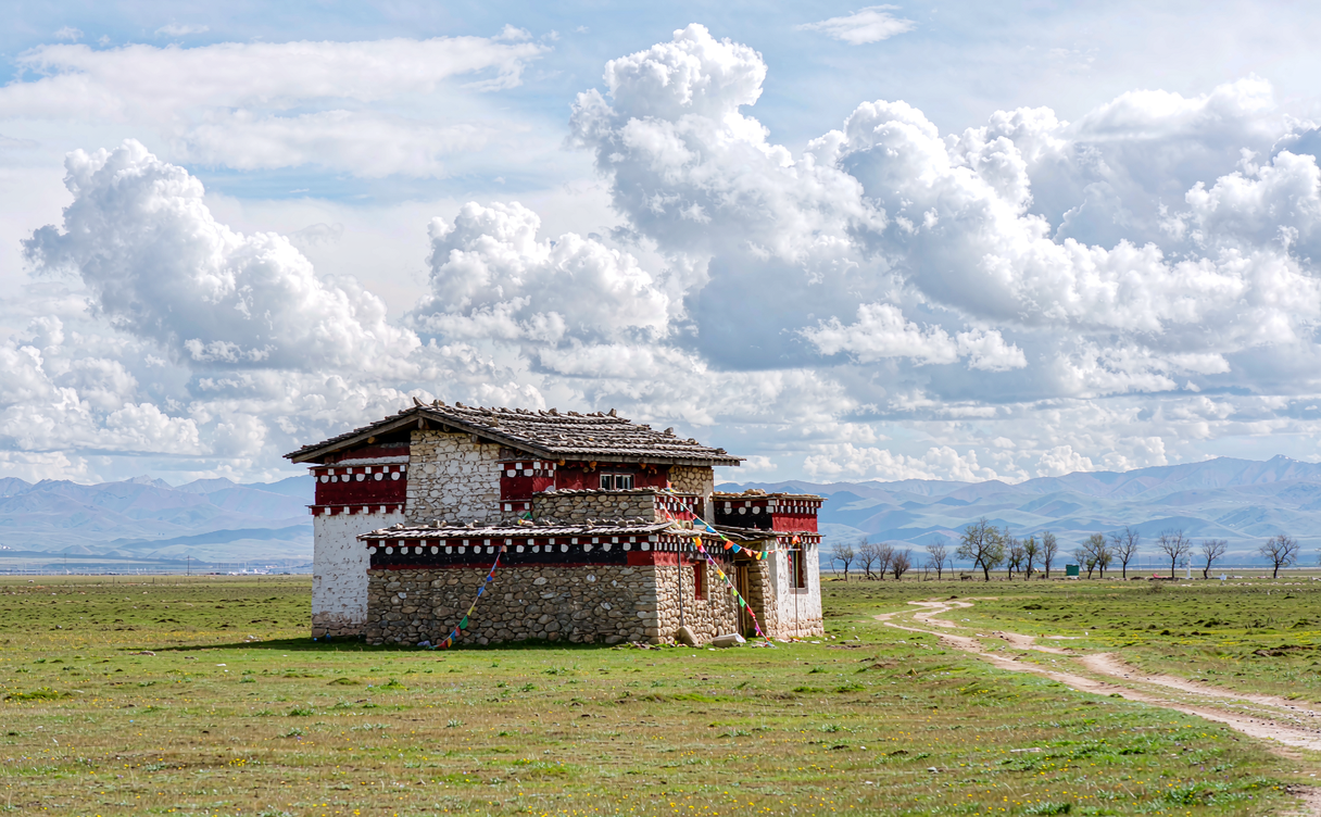 Litang monastery golden rooftops against a wide Sichuan plateau sky