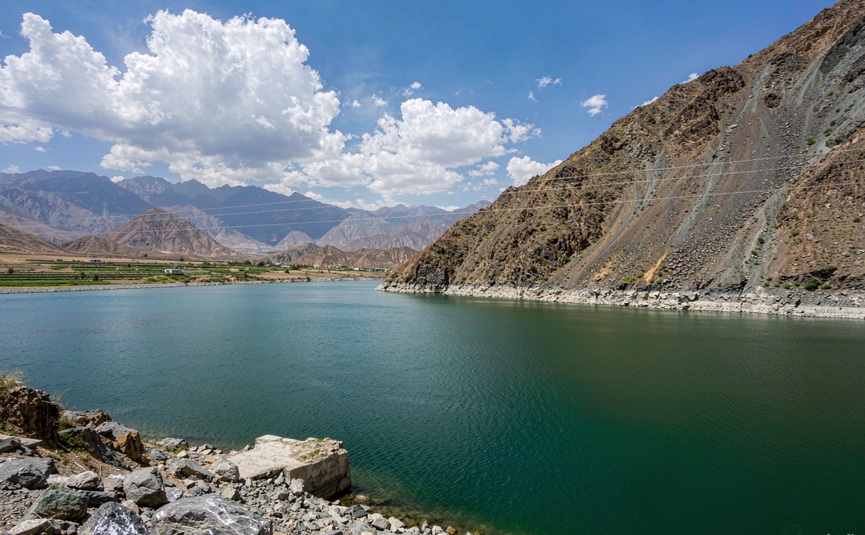 Turquoise Longyangxia reservoir water winding between red canyon walls under a clear Qinghai sky