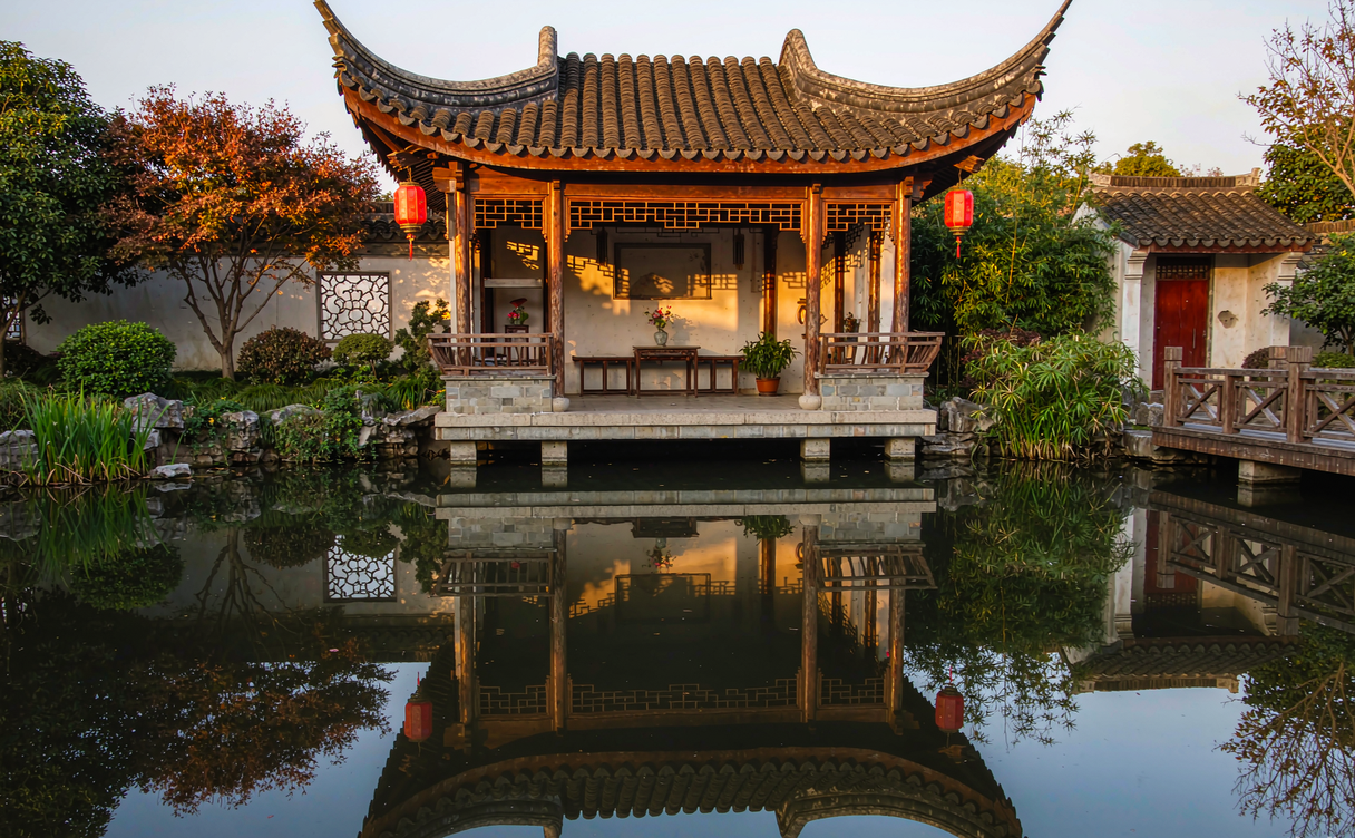 Quiet evening reflection of a pavilion in the Master of the Nets Garden's central pond