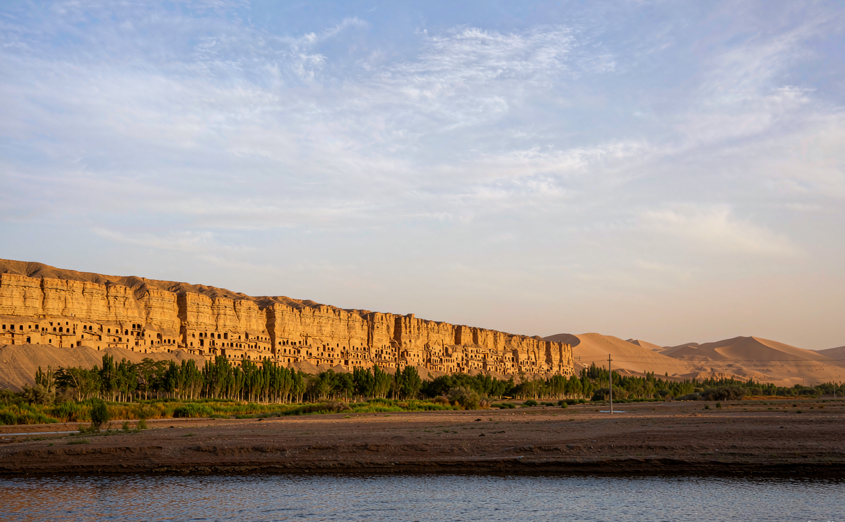Tang dynasty Buddha statue inside a Mogao Cave lit by flashlight