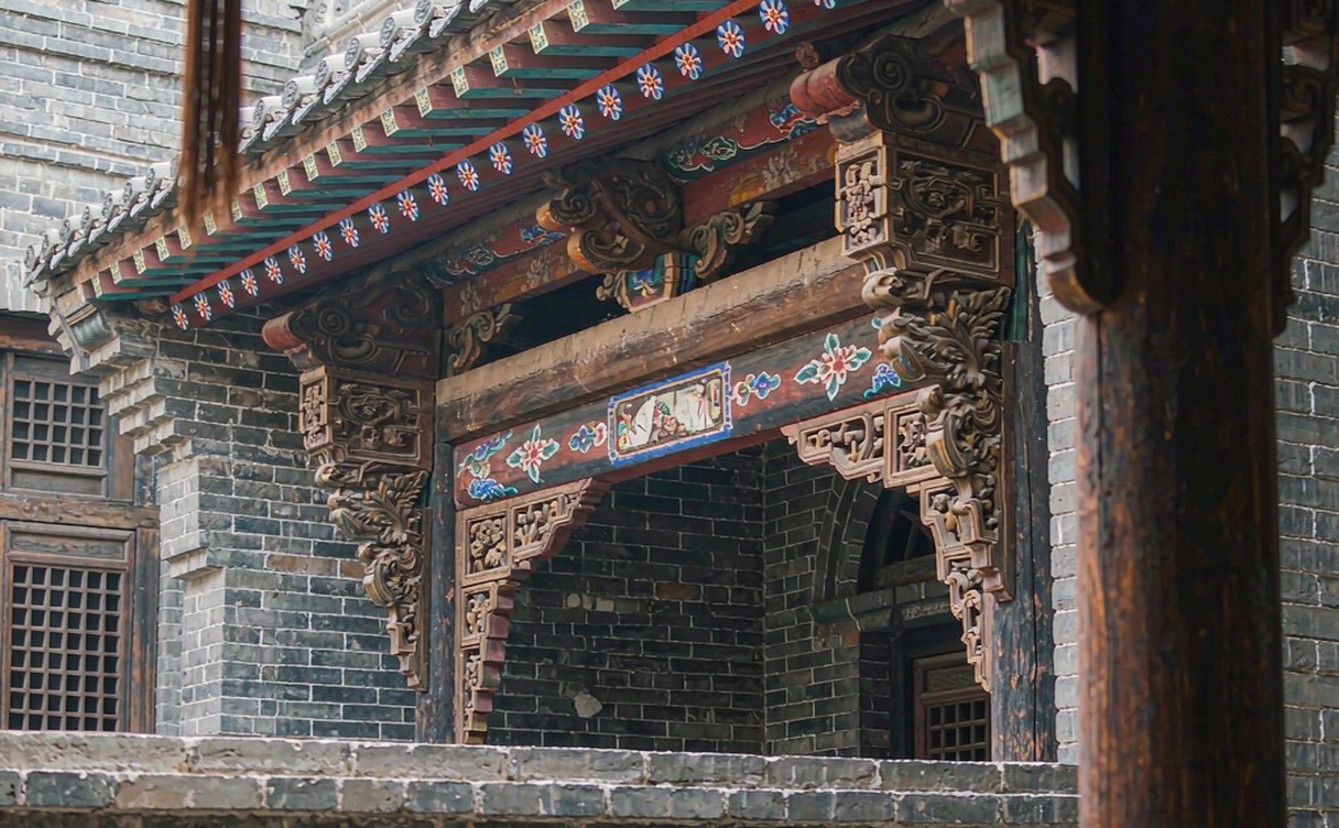 Inner courtyard of the Qiao Family Compound with a decorative brick screen wall and red lanterns