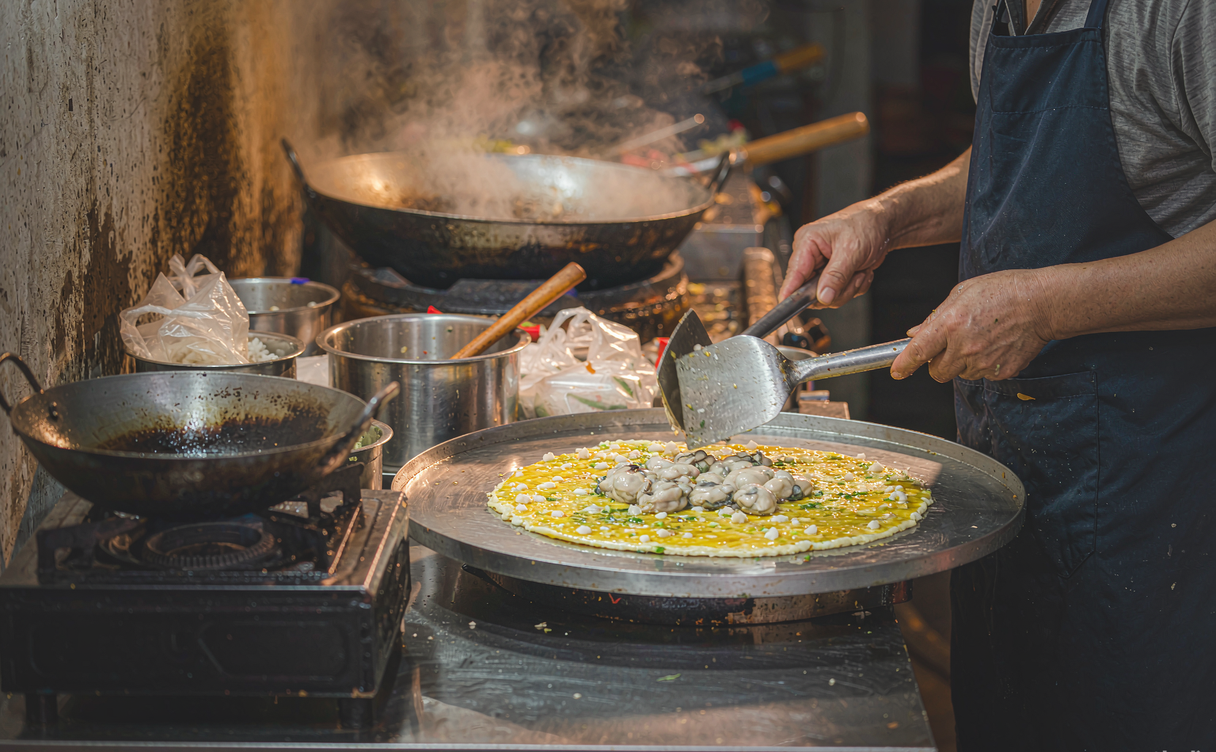 Street vendor in Shantou frying a fresh oyster omelet