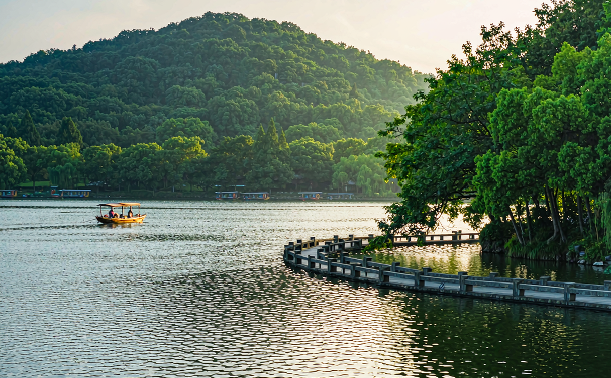 Taiping Lake in Anhui, China with calm emerald water mirroring distant green hills at dawn