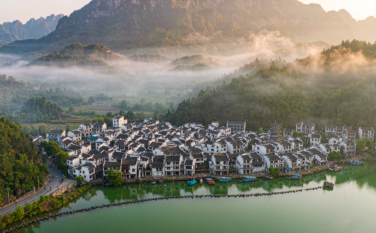 A kayak gliding past a small wooded islet on Taiping Lake, Anhui, China at sunrise