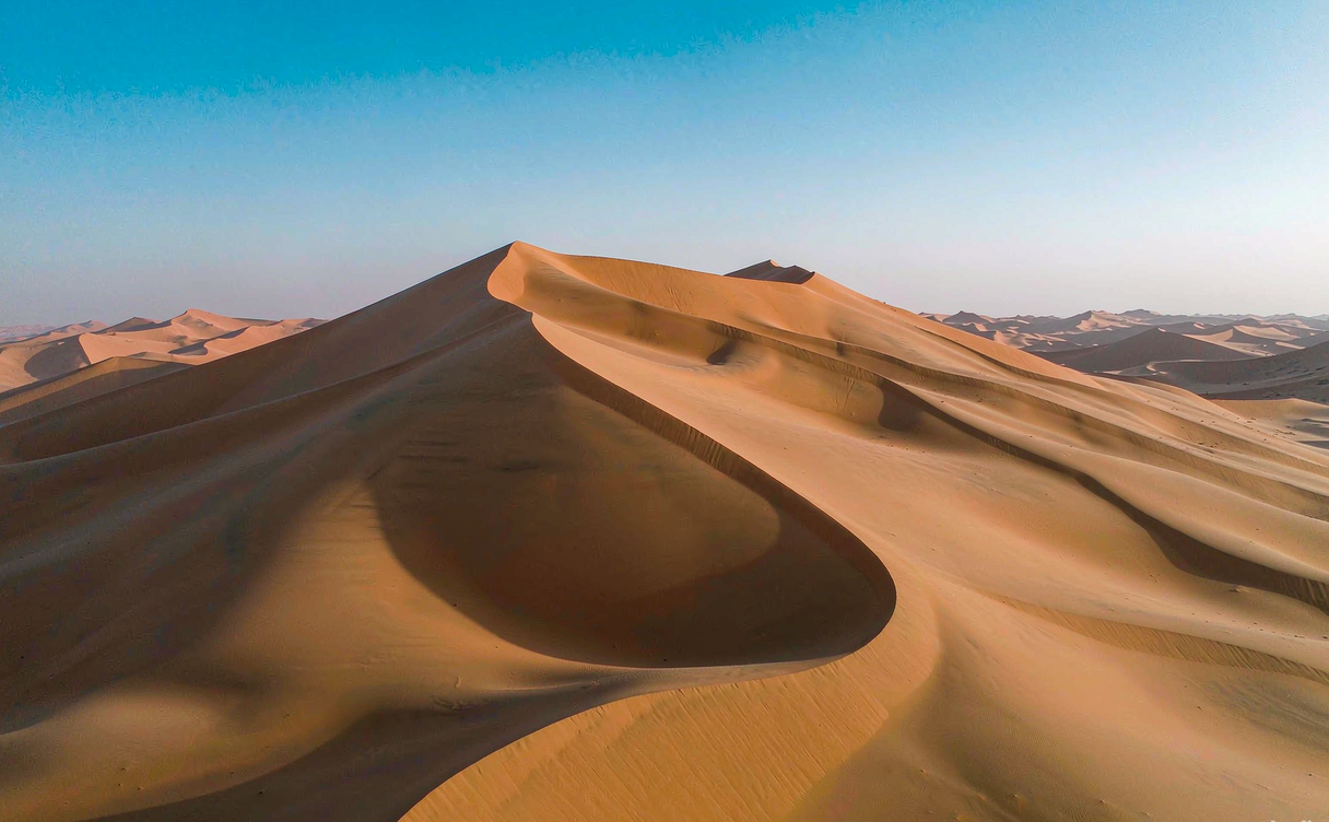 Vehicle on Tarim Desert Highway surrounded by Taklimakan dunes
