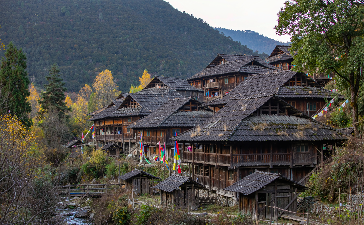 Timber Lisu houses with shingle roofs on a hillside in Weixi