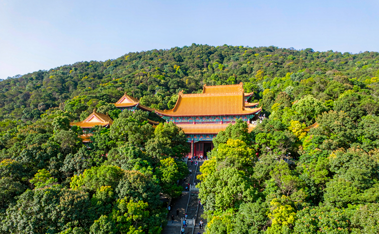 Mountain temple roof among dense subtropical forest on Xiqiao Mountain