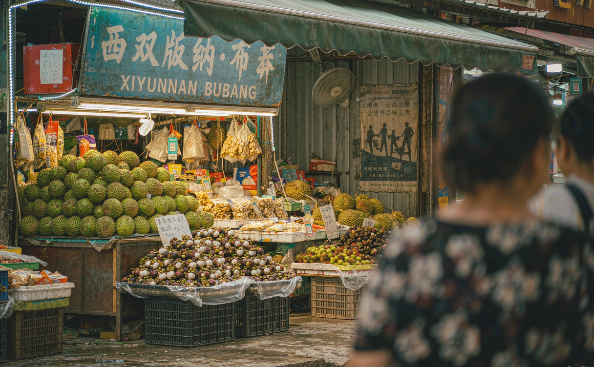 Evening food stalls under blue umbrellas at a Xishuangbanna night market