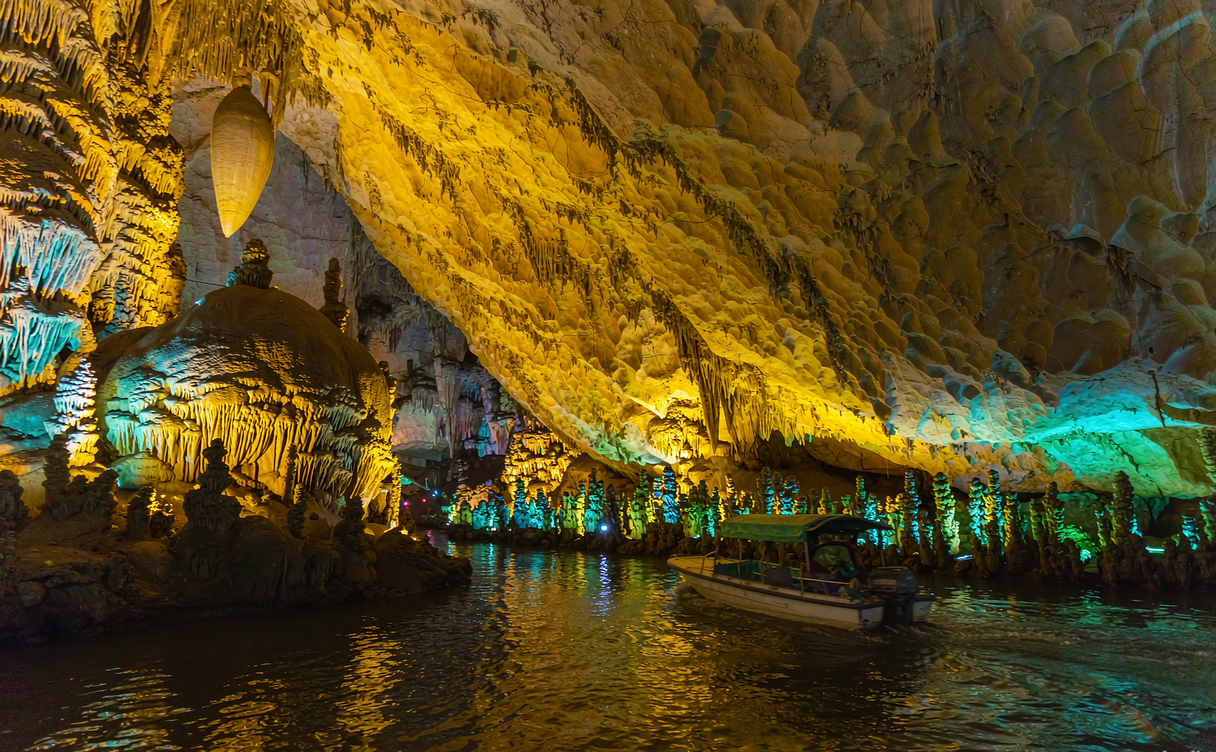 Floodlit stalactites and pillars inside Yellow Dragon Cave