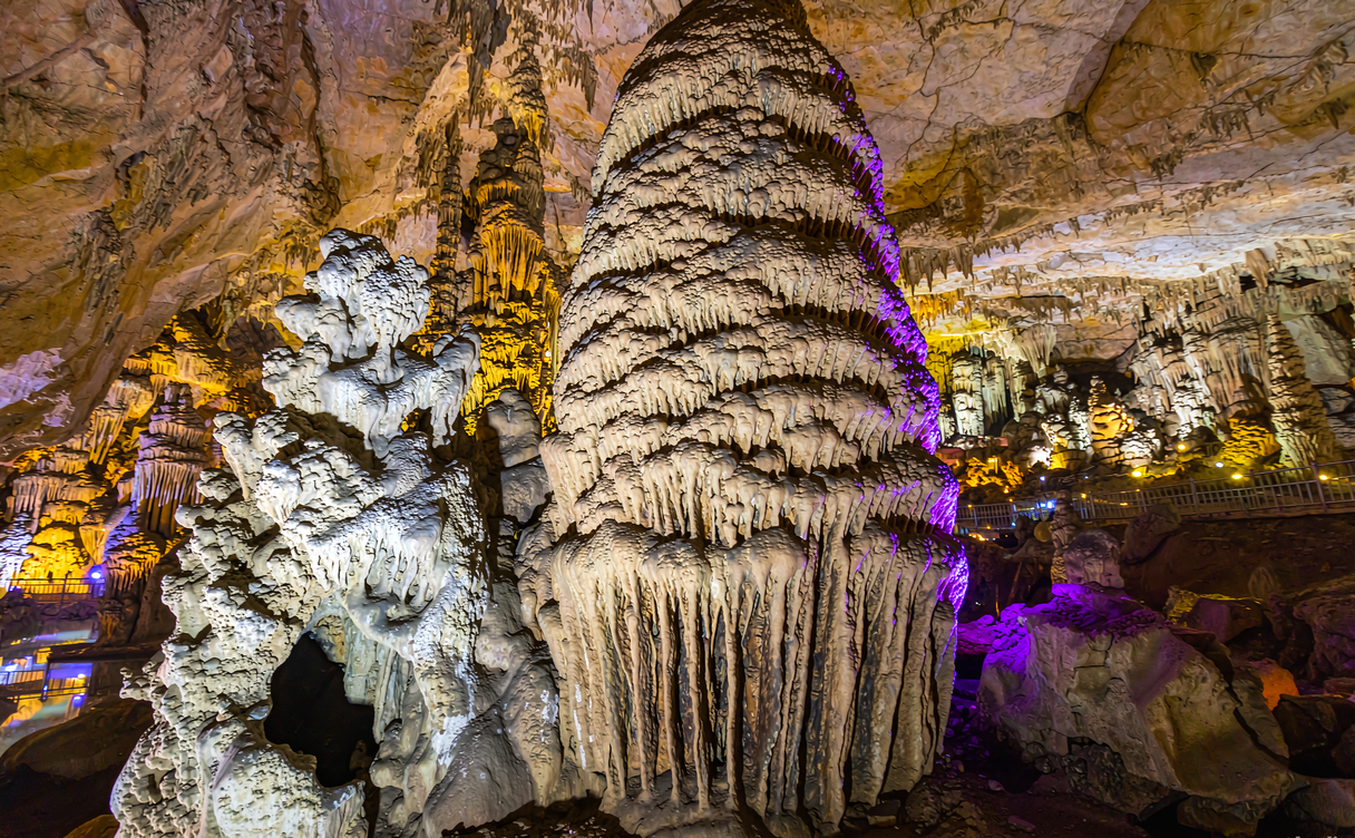 Boat on the illuminated underground lake of Yellow Dragon Cave