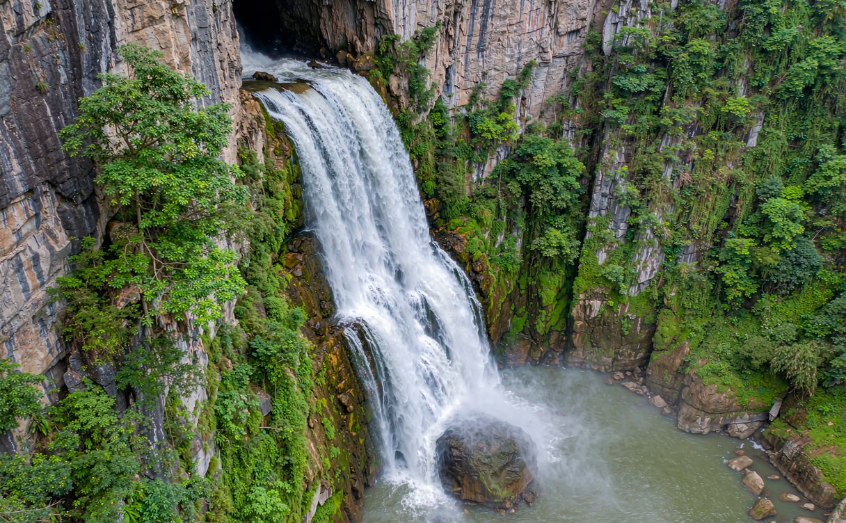 The emerald Tongling Gorge waterfall plunging through karst cliffs in Jingxi, Guangxi, China