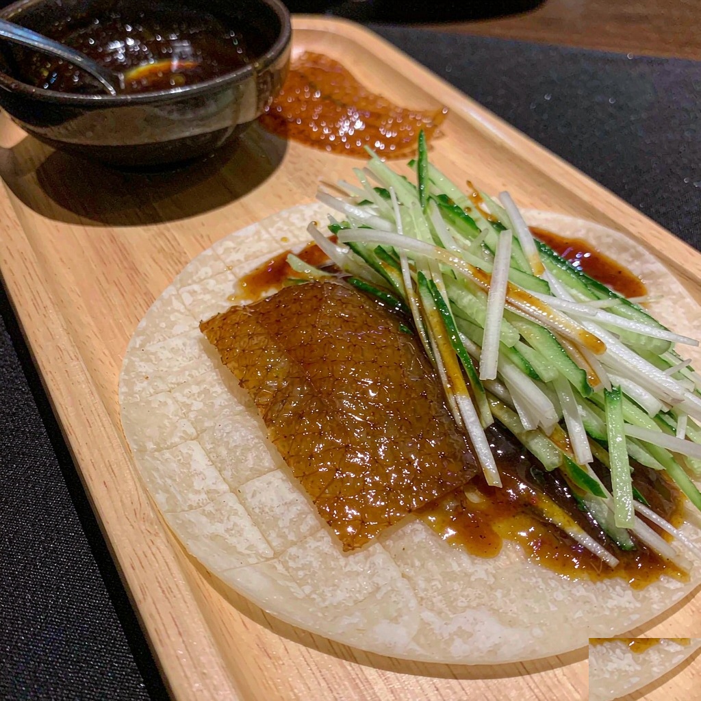Peking duck skin with julienned cucumber and spring onion on a thin steamed Mandarin pancake with sweet bean sauce